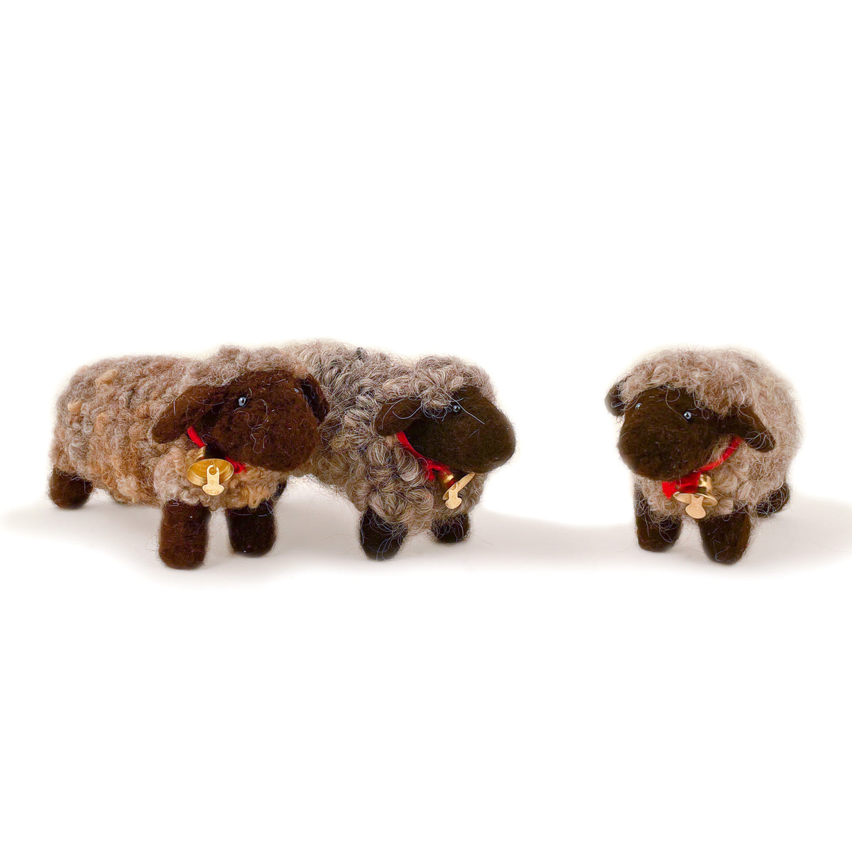 Three felted wool sheep in gray wool showing different variations of gray wool coloring